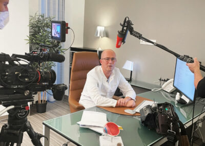 Dr. Werner sitzend mit Tonangel und Kamera auf ihn gerichtet