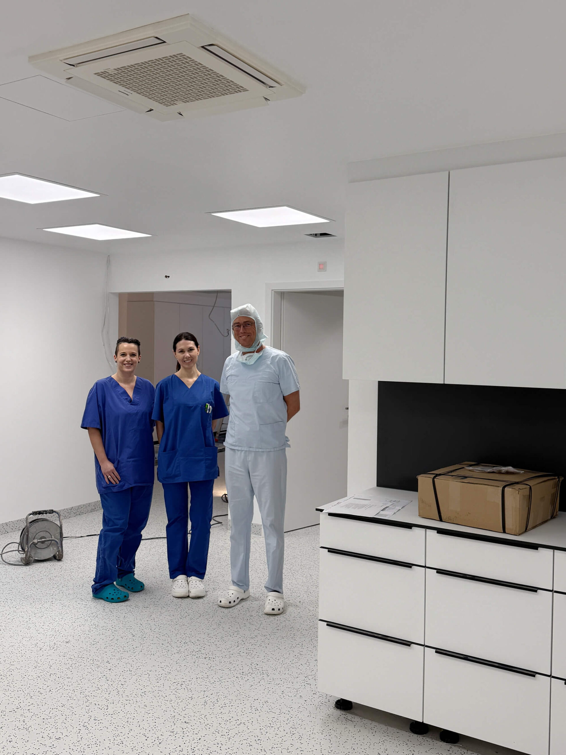 Dr. Werner und zwei Teammitglieder in alten OP-Räumen